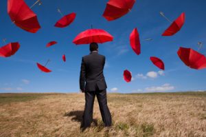 Man with Umbrella in a field with other umbrellas in ty