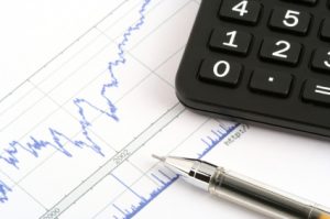 ballpoint pen and calculator on print stock chart