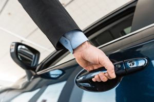 Close up photo of young man hand touching and openning new car. Concept for car rental