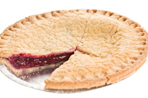 "A  high angle close up of a berry pie with a slice missing, the pie is in a tin baking plate."