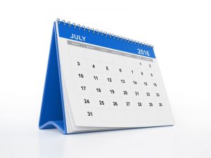 A monthly calendar with curled pages. July page is in focus. The calendar is blue in colour and standing on a white reflective background. Isolated on white. Clipping path is included.